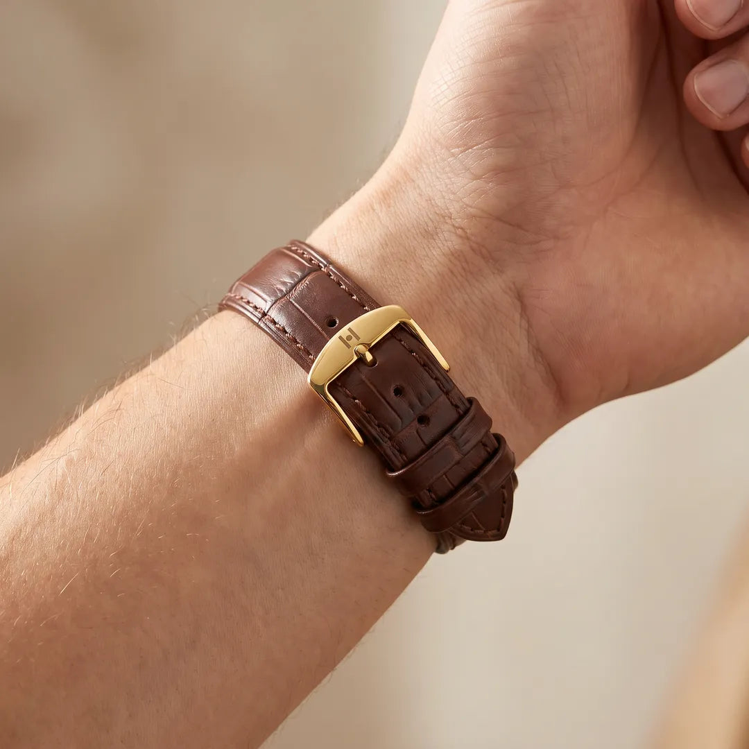 Man wearing the Duke brown alligator embossed leather watch band, inner wrist showing gold buckle with H engraving