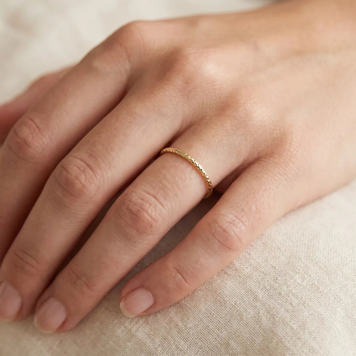 9K Yellow Gold Solid Diamond Cut Stacker Ring worn on a model's ring finger
