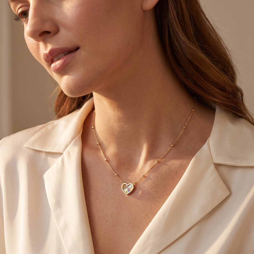 9K Yellow Gold Rainbow Heart Necklace worn on model, collarbone close-up