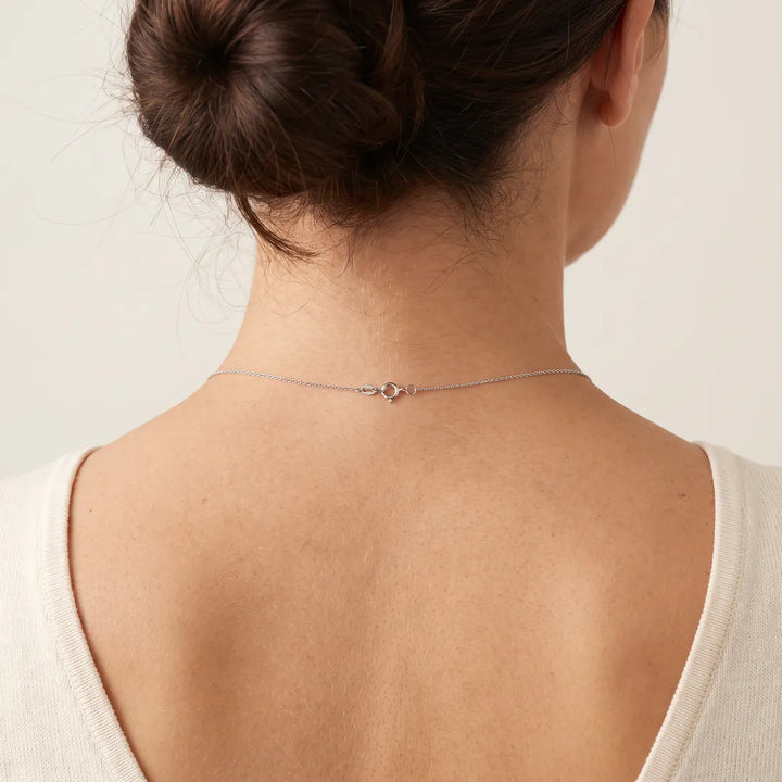 9K White Gold Fine Cable Chain worn at the nape, spring-ring clasp visible