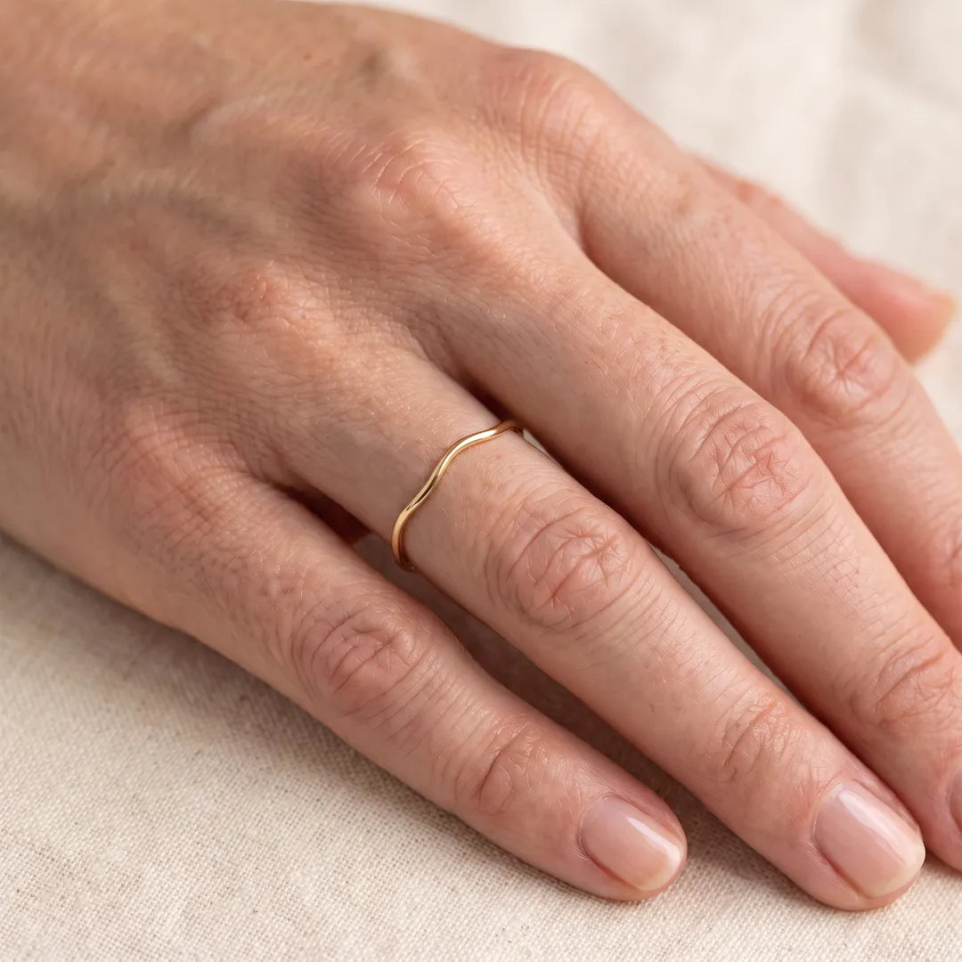 9K Yellow Gold Wavey Ring worn on a woman's ring finger, close-up