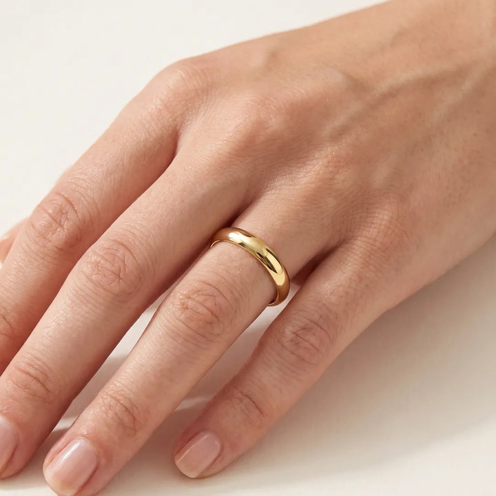9K Yellow Gold Plain Band worn on a model's ring finger, polished domed profile in warm yellow gold