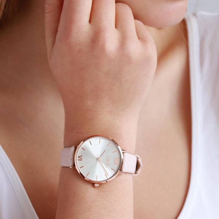 Jag Sophie silver alloy 36mm watch with a pale pink strap on a woman's wrist.