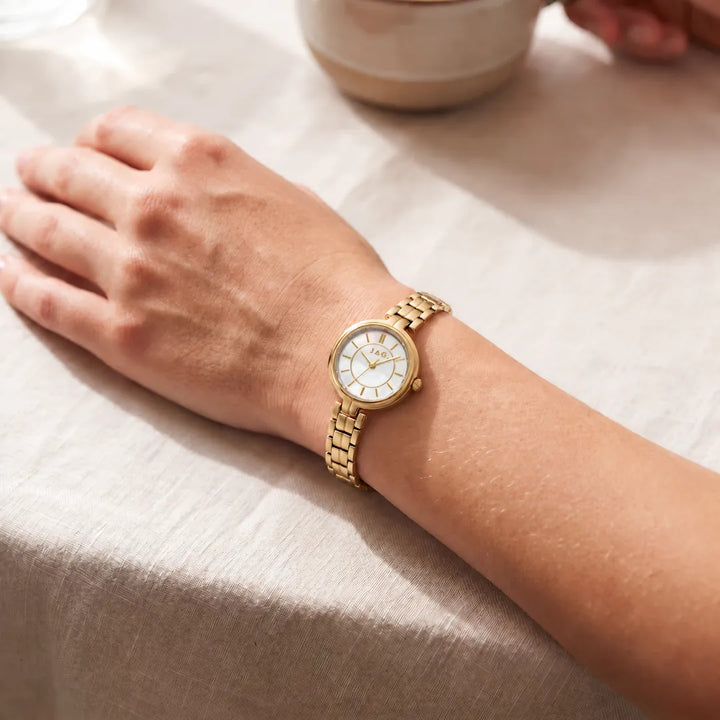 Jag Kelly womens 27mm gold watch with white mother-of-pearl dial worn on wrist