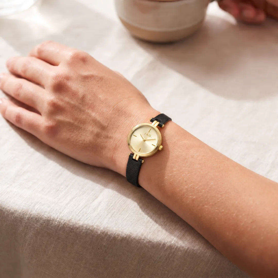 JAG Freya womens 27mm gold sunray dial watch with black leather strap worn on wrist