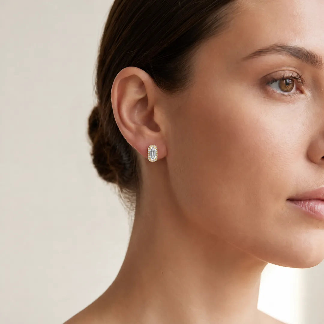 Woman wearing a 1.78ct lab grown diamond Northern Ray elongated cushion halo stud earring in 18K yellow gold, close-up on the ear