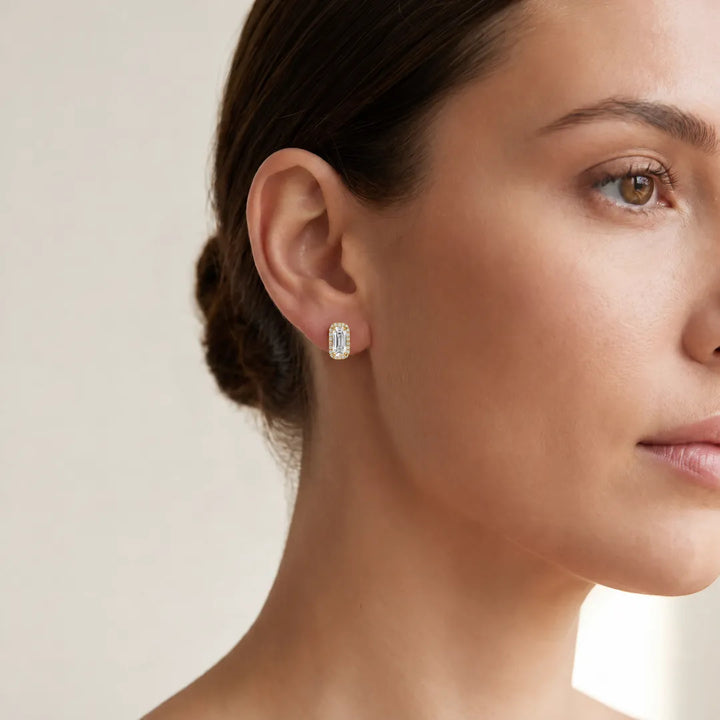 Woman wearing a 1.78ct lab grown diamond Northern Ray elongated cushion halo stud earring in 18K yellow gold, close-up on the ear