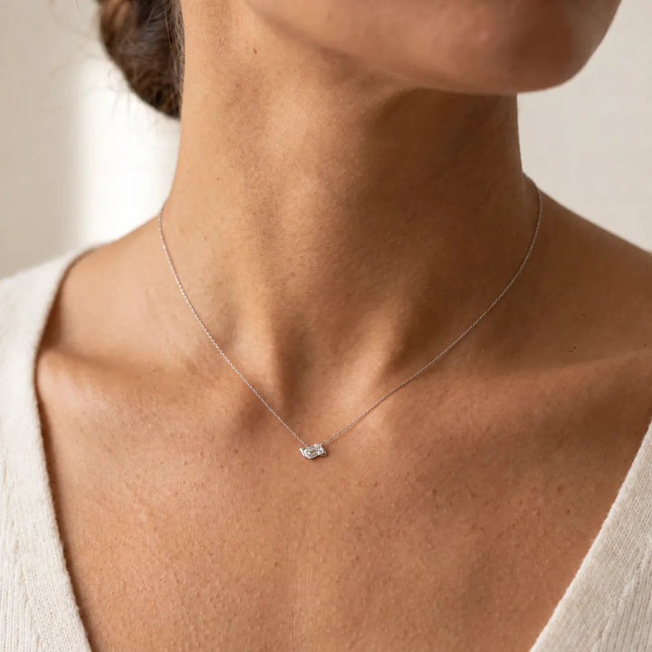 0.50ct Lab Grown Diamond Asterly Necklace in 9K White Gold worn on a model, emerald-cut half-bezel pendant on a fine chain at the base of the neck