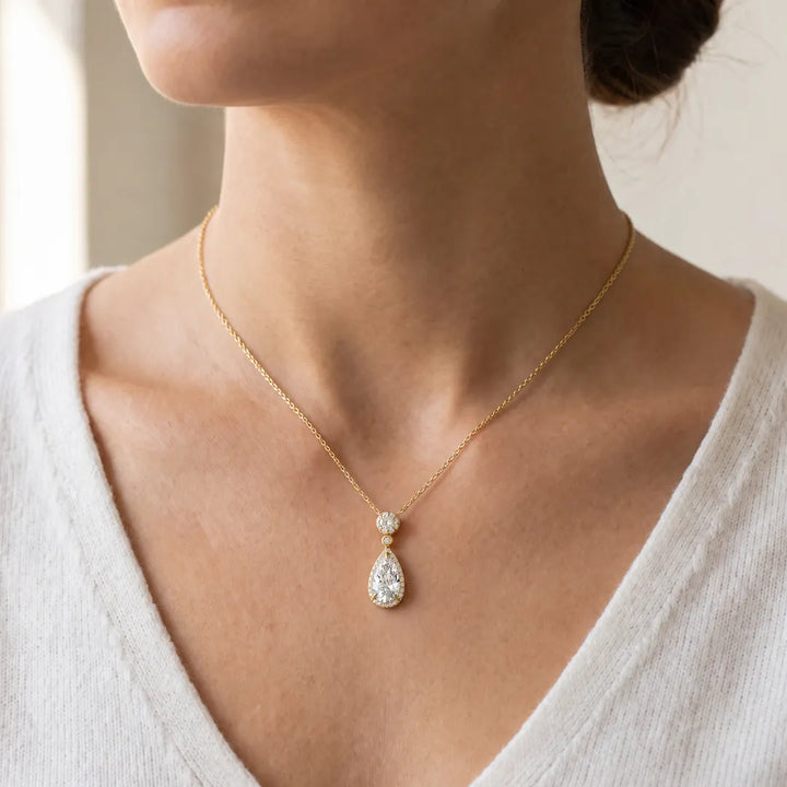 3.45ct Elongated Pear Lab Grown Diamond Necklace in 18K Yellow Gold worn on a model, pear halo pendant with round halo top on a fine yellow gold chain at the base of the neck