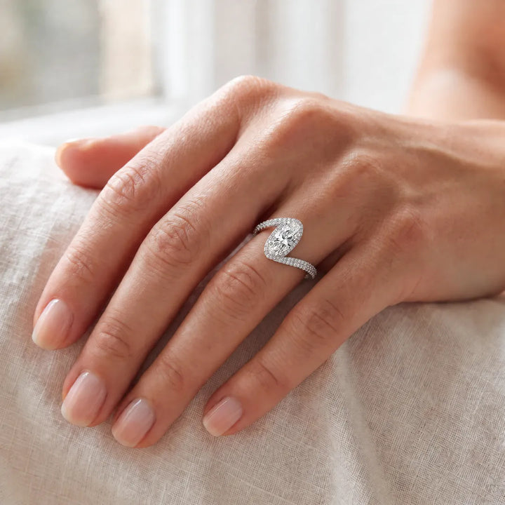 3.70ct elongated oval lab grown diamond bypass halo ring in platinum worn on a woman's hand