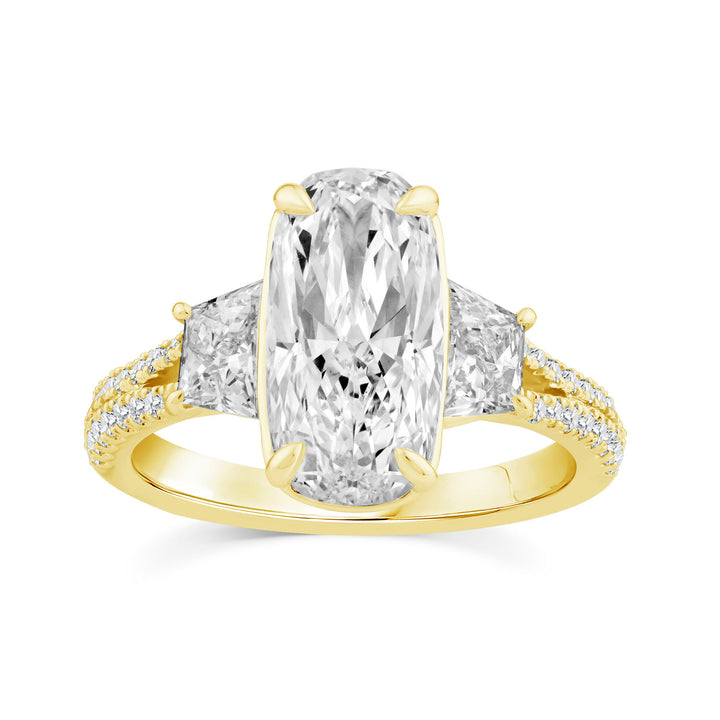 A yellow gold ring featuring a large oval-cut center stone with two smaller pear-cut side stones and a row of small pavé diamonds along the shoulders, set against a plain white background.