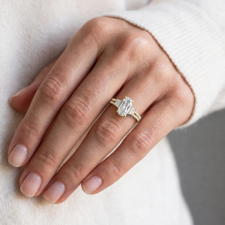 4.00ct lab grown diamond Northern Ray three-stone ring in 18K yellow gold worn on a woman's hand