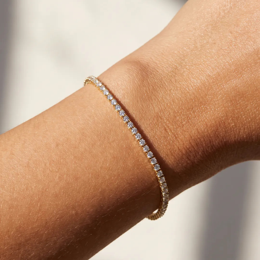2.00ct lab grown diamond tennis bracelet in 9K yellow gold worn on a woman's wrist
