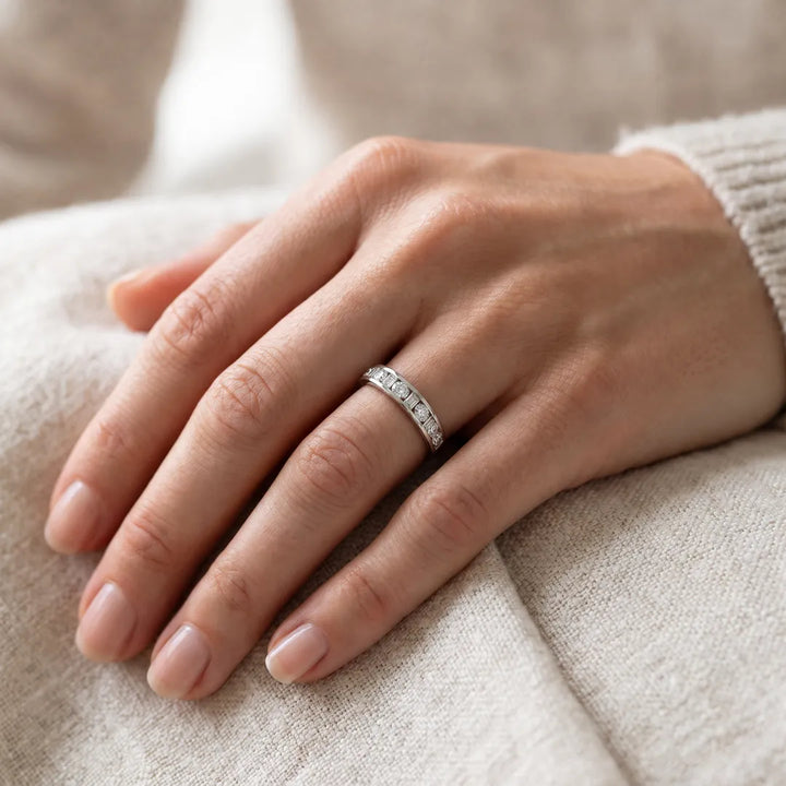 1.50ct emerald and round lab grown diamond channel-set ring in 9K white gold worn on a model's hand
