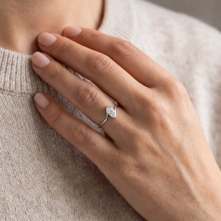 1.00ct marquise lab grown diamond bezel-set accent ring in 9K white gold worn on a model's hand