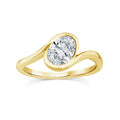 A gold solitaire ring with a round brilliant-cut diamond, resting on a soft beige fabric surface with a blurred background.