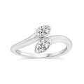 A silver-tone ring featuring two marquise-cut clear gemstones set in a flowing, wave-like band design, shown on a plain white background.