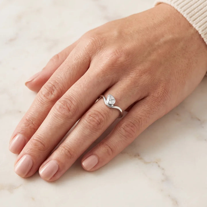0.50ct Pear Lab Grown Diamond Offset Ring in 9K White Gold worn on a woman's hand