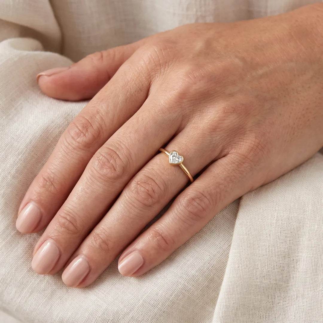 0.20ct heart lab grown diamond ring in 9K yellow gold worn on a woman's ring finger