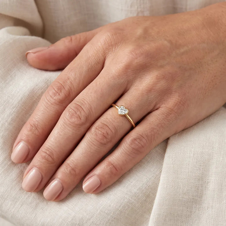 0.20ct heart lab grown diamond ring in 9K yellow gold worn on a woman's ring finger