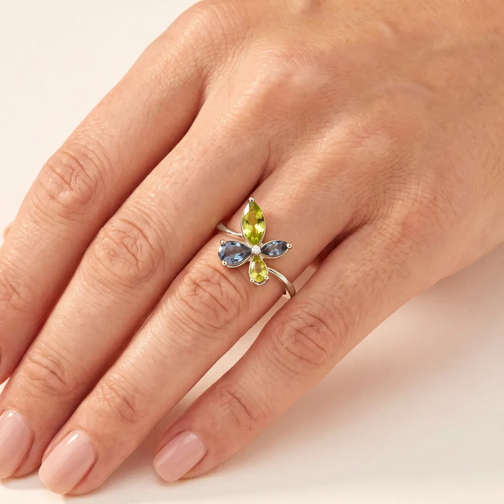 0.01ct Diamond, Topaz & Peridot butterfly cluster ring in 9K white gold worn on a model's ring finger